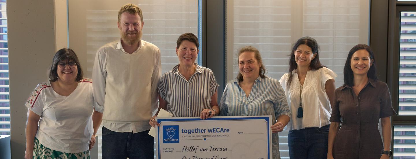 groupe de personnes tenant un chèque de 1000€